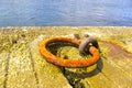 Closeup shot of an old,  rusty mooring ring at the harbor Royalty Free Stock Photo