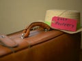 Closeup shot of an old suitcase and a hat on it with label inscription Lost property``