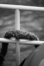 Closeup shot of an old thick rope on a metal railing. Royalty Free Stock Photo