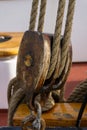 Closeup shot of old wooden pulley with thick ropes on a blur background