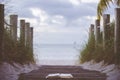 Closeup shot of an open bible on a wooden pathway towards the beach with a blurred background Royalty Free Stock Photo