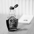 Closeup shot of an open bottle of maple syrup on the table. Royalty Free Stock Photo