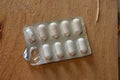 Closeup shot of a pack of pills on a wooden surface