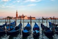 Closeup shot of parked gondolas with  Venice scenes on the background Royalty Free Stock Photo