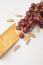 Closeup shot of parmesan cheese, almond and grapes on white Royalty Free Stock Photo