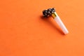 Closeup shot of a party noisemaker isolated on an orange background