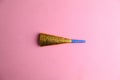 Closeup shot of a party noisemaker isolated on a pink background