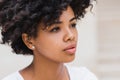 Closeup shot of pensive beautiful African American young woman have sad face, against white wall with copy space for your text or Royalty Free Stock Photo