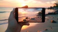 closeup shot of person holding mobile phone in hand and taking photo of sunset at sea, nature photography with Royalty Free Stock Photo