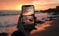 closeup shot of person holding mobile phone in hand and taking photo of sunset at sea, nature photography with Royalty Free Stock Photo