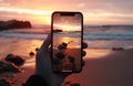 closeup shot of person holding mobile phone in hand and taking photo of sunset at sea, nature photography with Royalty Free Stock Photo