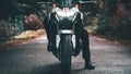 Closeup shot of a person on a Kawasaki Z900 Naked motorbike in the forest