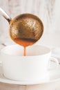 Closeup shot of a person pouring tomato soup in the bowl Royalty Free Stock Photo