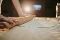 Closeup shot of a person preparing dough for pizza with a rolling pin Royalty Free Stock Photo