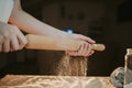 Closeup shot of a person preparing dough for pizza with a rolling pin Royalty Free Stock Photo