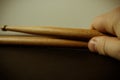 Closeup shot of a person's hand holding two drum sticks on a black surface Royalty Free Stock Photo