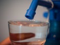 Closeup shot of a person's hand pouring fresh tap water into a glass Royalty Free Stock Photo