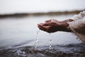 Closeup shot of a person wearing a biblical robe drinking water with hands Royalty Free Stock Photo