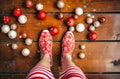 Closeup shot of a person's feet wearing red and white socks on a Christmas background, Ai-generated. Royalty Free Stock Photo