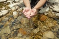 Closeup shot of a persons hand picking up water from a lake