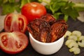 Closeup shot of pickled chicken in a small white bowl and fresh tomatoes Royalty Free Stock Photo