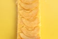 Closeup shot of a piece of apple pie on a yellow surface