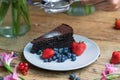 Closeup shot of a piece of brownie cake with blueberries and strawberries