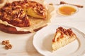 Closeup shot of a piece of delicious apple walnut cake with honey surrounded by ingredients