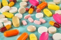 Closeup shot of a pile of scattered colorful medicines on the cyan background