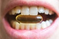 Closeup shot of a pill between a woman\'s teeth Royalty Free Stock Photo