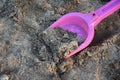 Closeup shot of a pink plastic toy shovel on sand Royalty Free Stock Photo