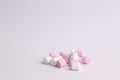 Closeup shot of pink and white mini marshmallows on a white background