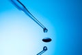 Closeup shot of a pipette tip with a liquid droplet