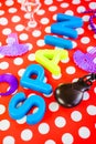 Closeup shot plastic letters spelling [SPAIN} purple ornaments castanets on red dotted background