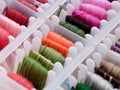 A closeup shot of a plastic sorting box full of bobbins with different colour embroidery threads Royalty Free Stock Photo
