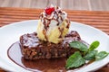 Closeup shot of a plate of a brownie cake and melted ice cream