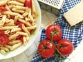 Closeup shot of a plate full of Italian pasta with sliced cherry tomatoes and spices