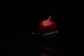 Closeup shot of pomegranate with a small sieve on black background Royalty Free Stock Photo