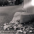 Closeup shot of popcorns left in the street in black and white