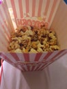 Closeup shot of popcorns in the white and pink striped box