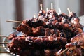 Closeup shot of pork barbecue on wooden sticks on a tray in a blurred background Royalty Free Stock Photo