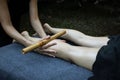 Closeup shot of a professional relaxing feet massage with a wooden stick