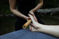 Closeup shot of a professional relaxing feet massage with a wooden stick