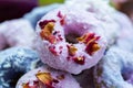 Closeup shot of purple and blue vegan donuts covered with edible rose flowers Royalty Free Stock Photo