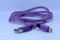 Closeup shot of a purple USB charging cable on a white surface Royalty Free Stock Photo