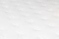 Closeup shot of a quilted white mattress with soft flowers pattern Royalty Free Stock Photo