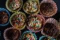 Closeup shot of rainbow sprinkle munchkins on paper muffin cups