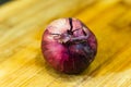 Closeup shot of a raw red onion on a wooden surface Royalty Free Stock Photo