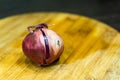 Closeup shot of a raw red onion on a wooden surface Royalty Free Stock Photo