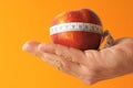 Closeup shot of a red apple with measuring centimetric tape on the hand Royalty Free Stock Photo